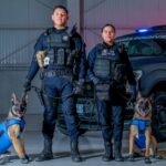 Elementos de seguridad de Aguascalientes con perros entrenados frente a una patrulla