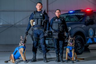 Elementos de seguridad de Aguascalientes con perros entrenados frente a una patrulla