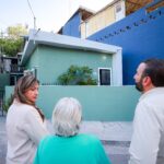 Mauricio Farah Giacomán y vecinas observan una fachada rehabilitada en la colonia Jesús M. Garza de San Pedro Garza García