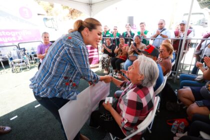 Marina del Pilar Ávila Olmeda saluda a una mujer adulta mayor durante una jornada de apoyos en Baja California.