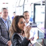 Tere Jiménez muestra una tarjeta de transporte público durante la presentación de nuevas unidades en Aguascalientes.