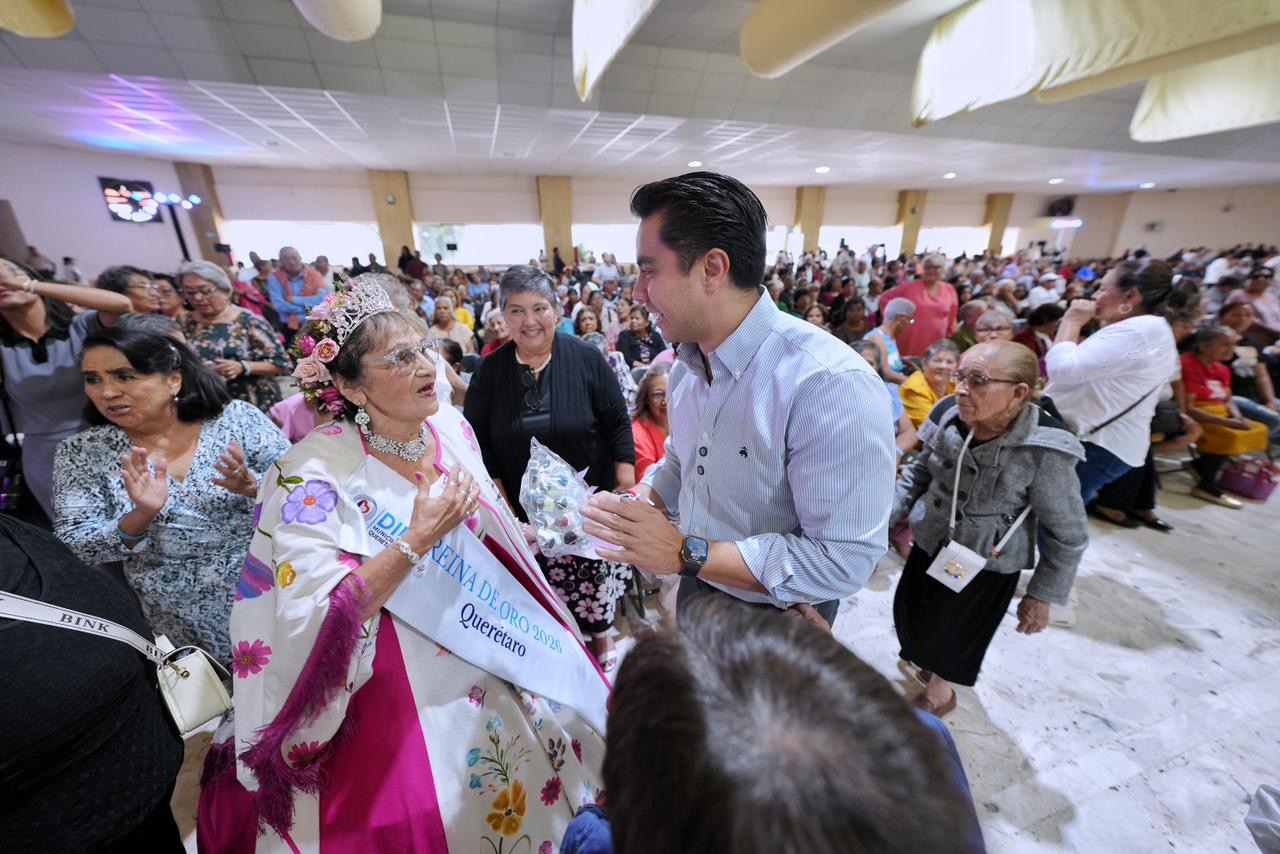 Felifer Macías saluda a una asistente durante la celebración del Día de las Personas Adultas Mayores Baile de Plata en Querétaro.