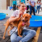 Marina del Pilar Avila Olmeda convive con un perro durante una actividad de promoción de adopción responsable en Baja California.
