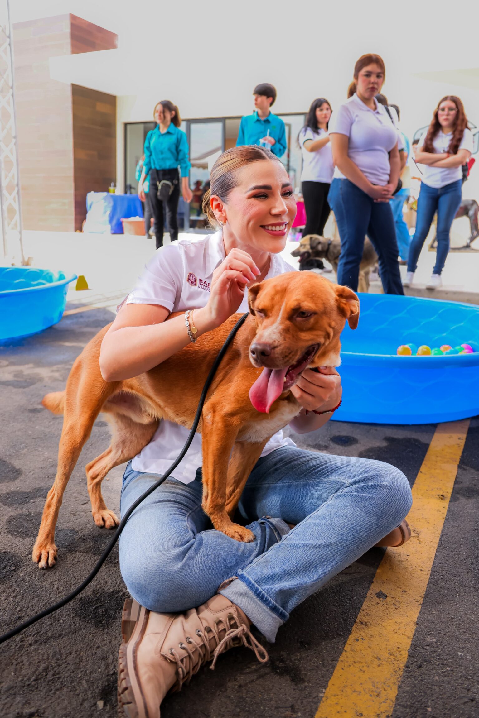 Marina del Pilar Avila Olmeda convive con un perro durante una actividad de promoción de adopción responsable en Baja California.