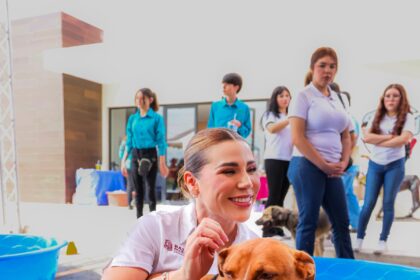 Marina del Pilar Avila Olmeda convive con un perro durante una actividad de promoción de adopción responsable en Baja California.