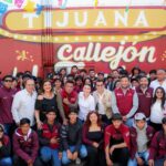 Autoridades y jóvenes participan en una actividad del Proyecto Tijuana: Ruta de la Paz frente a un mural en Tijuana.