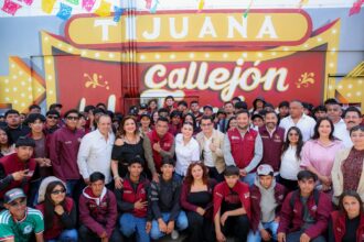 Autoridades y jóvenes participan en una actividad del Proyecto Tijuana: Ruta de la Paz frente a un mural en Tijuana.