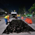 Trabajadores realizan labores nocturnas de mantenimiento vial y bacheo en una avenida del municipio de Querétaro.
