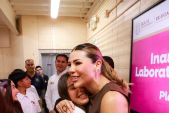 Marina del Pilar Avila Olmeda saluda a una estudiante durante la entrega de equipamiento tecnológico en el CECyTE Altiplano, en Baja California.