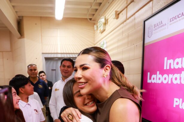 Marina del Pilar Avila Olmeda saluda a una estudiante durante la entrega de equipamiento tecnológico en el CECyTE Altiplano, en Baja California.