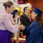 Marina del Pilar Avila Olmeda saluda a una mujer graduada durante un acto de certificación educativa en Baja California