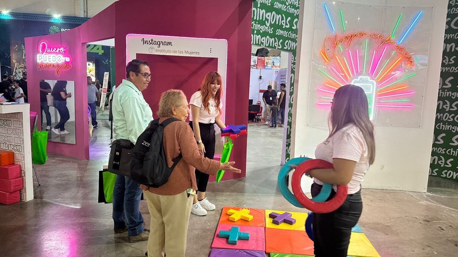 Personas participan en una actividad del Instituto de las Mujeres en un módulo instalado en la Feria Nacional Potosina.