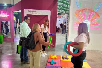 Personas participan en una actividad del Instituto de las Mujeres en un módulo instalado en la Feria Nacional Potosina.