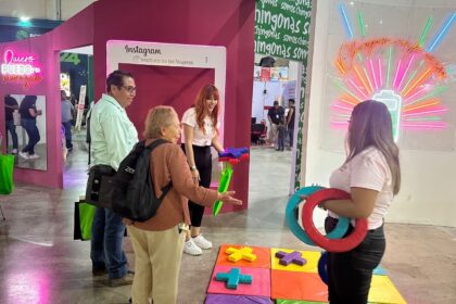 Personas participan en una actividad del Instituto de las Mujeres en un módulo instalado en la Feria Nacional Potosina.