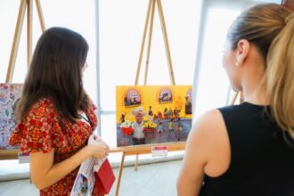 Asistentes observan obras del Concurso Nacional de Dibujo y Pintura Infantil y Juvenil durante una ceremonia en Baja California.