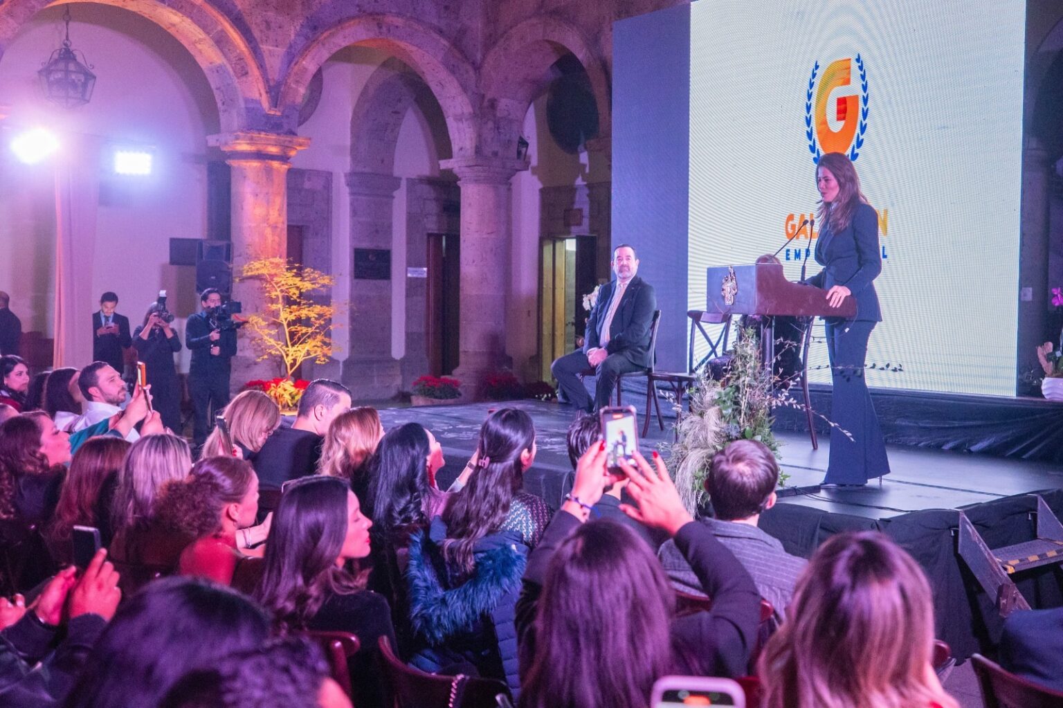Evento del Galardón Empresarial en Guadalajara con asistentes y una mujer hablando desde el escenario.