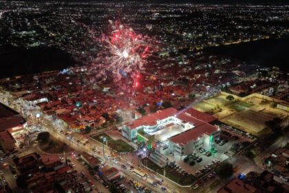 Vista aérea nocturna de Soledad de Graciano Sánchez durante un evento con fuegos artificiales y la Unidad Administrativa Municipal iluminada.
