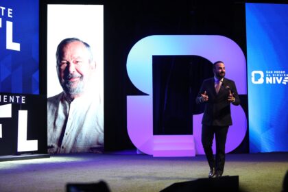 Mauricio Farah Giacomán durante la presentación del Informe Municipal de Resultados de San Pedro Garza García, con una imagen de Mauricio Fernández Garza en una pantalla del escenario.
