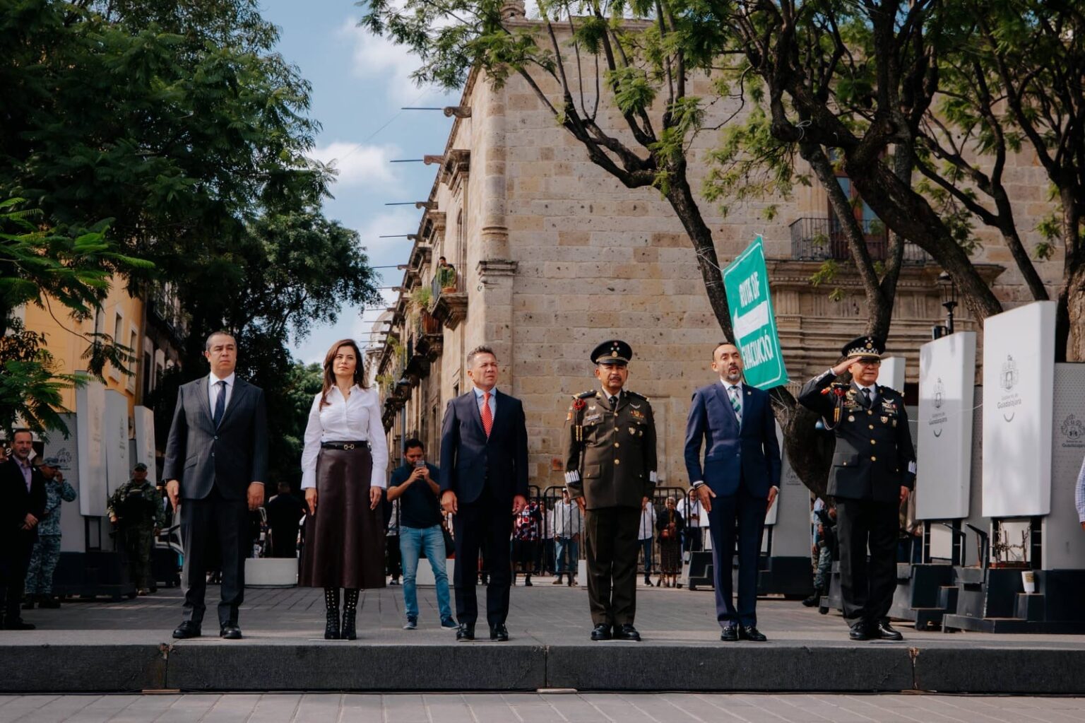 Autoridades municipales, estatales y militares durante una ceremonia de izamiento de Bandera en Guadalajara.