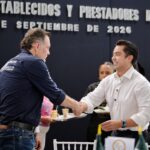 Felifer Macías saluda a un representante del sector comercial durante un encuentro de la FECOPSE en Querétaro.