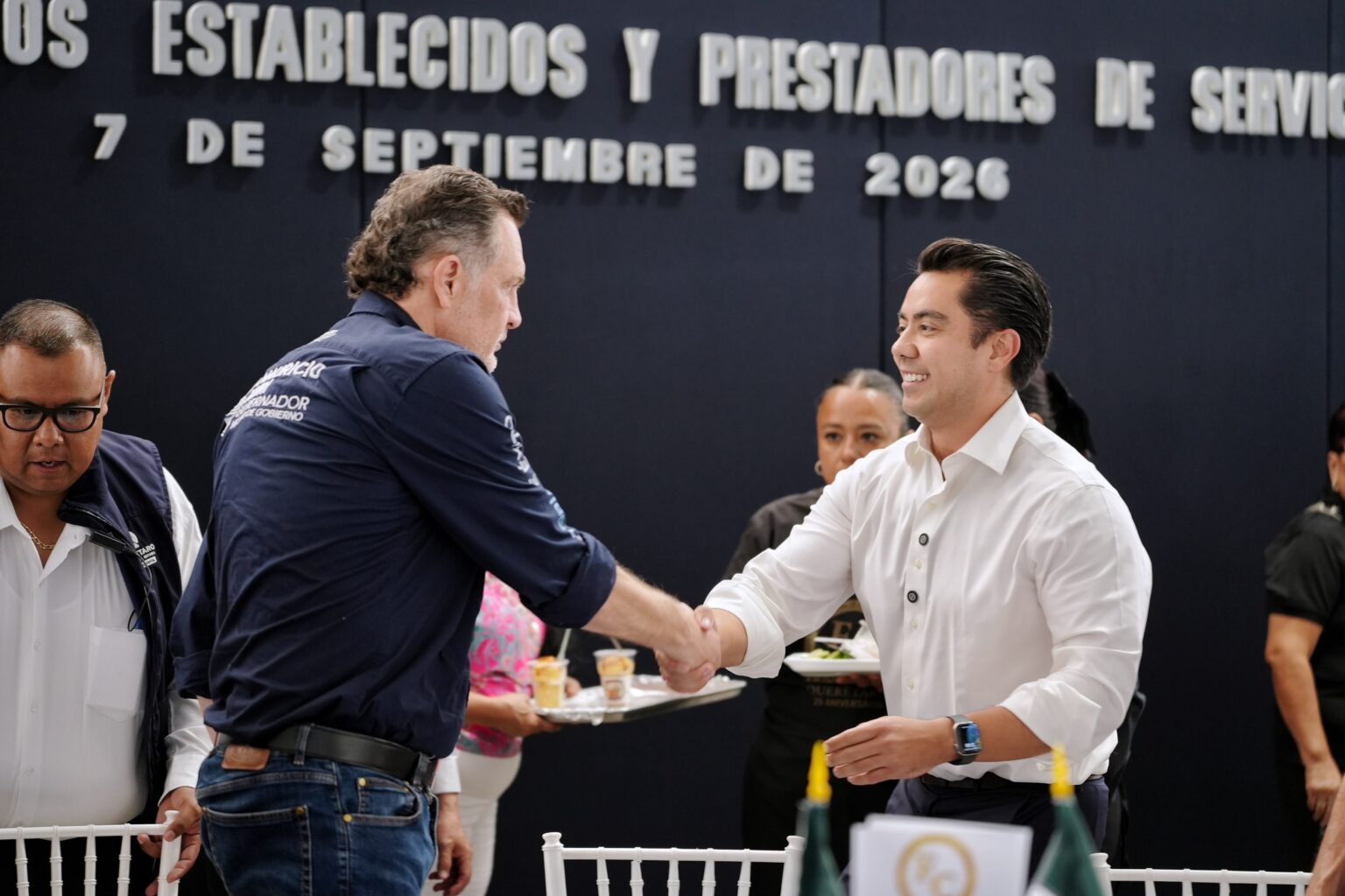 Felifer Macías saluda a un representante del sector comercial durante un encuentro de la FECOPSE en Querétaro.