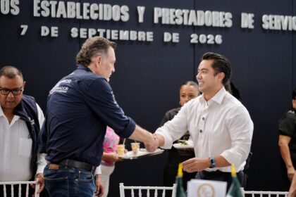 Felifer Macías saluda a un representante del sector comercial durante un encuentro de la FECOPSE en Querétaro.