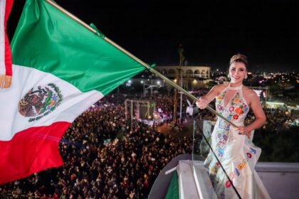 Ceremonia del Grito de Independencia en Mexicali con la Bandera de México y asistentes reunidos en el Centro Cívico.