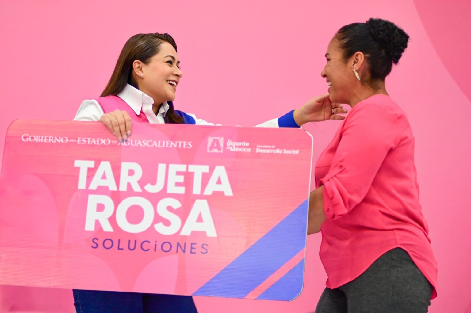 Tere Jiménez conversa con una beneficiaria durante un evento de entrega de la Tarjeta Rosa en Aguascalientes.