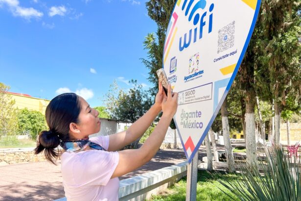 Persona escanea un código QR en un punto de conexión WiFi del Gobierno de Aguascalientes.