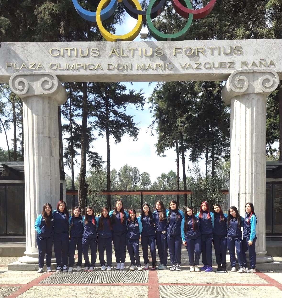 Equipo femenil de handball frente al acceso de la Plaza Olímpica Don Mario Vázquez Raña.