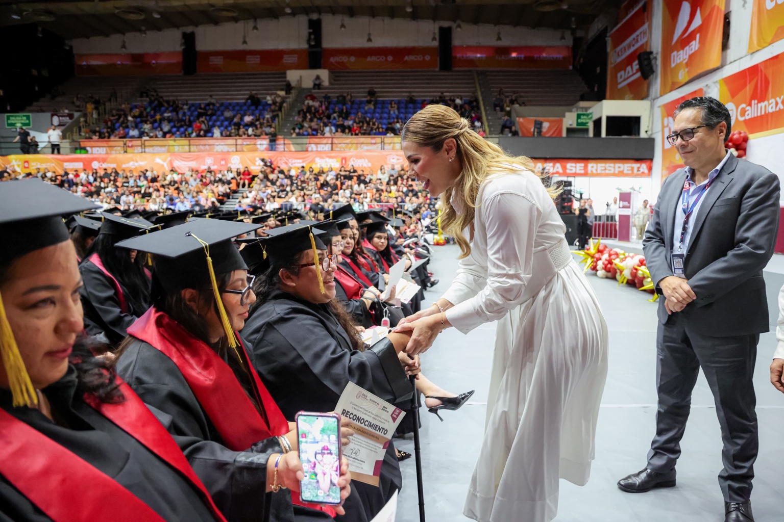 Marina del Pilar Avila Olmeda saluda a una de las graduadas del programa Tarjeta Violeta durante una ceremonia en Mexicali.