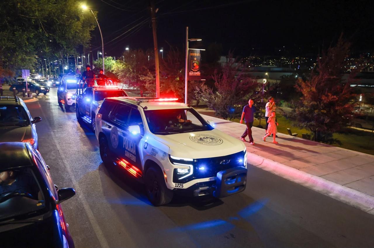 Patrullas de la Policía de San Pedro Garza García recorren una vialidad durante un operativo nocturno.