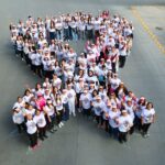 Mujeres forman un lazo humano rosa durante una jornada de concientización sobre el cáncer de mama en San Pedro de Pinta, en San Pedro Garza García.