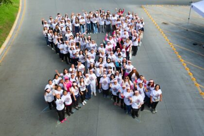 Mujeres forman un lazo humano rosa durante una jornada de concientización sobre el cáncer de mama en San Pedro de Pinta, en San Pedro Garza García.