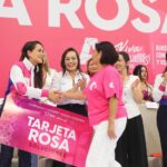 Durante un evento de Tarjeta Rosa en Aguascalientes, una funcionaria saluda a una beneficiaria frente a otras asistentes.