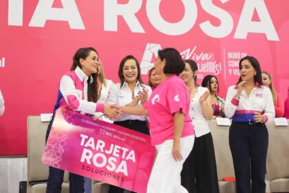Durante un evento de Tarjeta Rosa en Aguascalientes, una funcionaria saluda a una beneficiaria frente a otras asistentes.