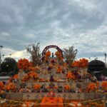Altar monumental de Día de Muertos decorado con flores de cempasúchil, figuras tradicionales y ofrendas en Zapopan.