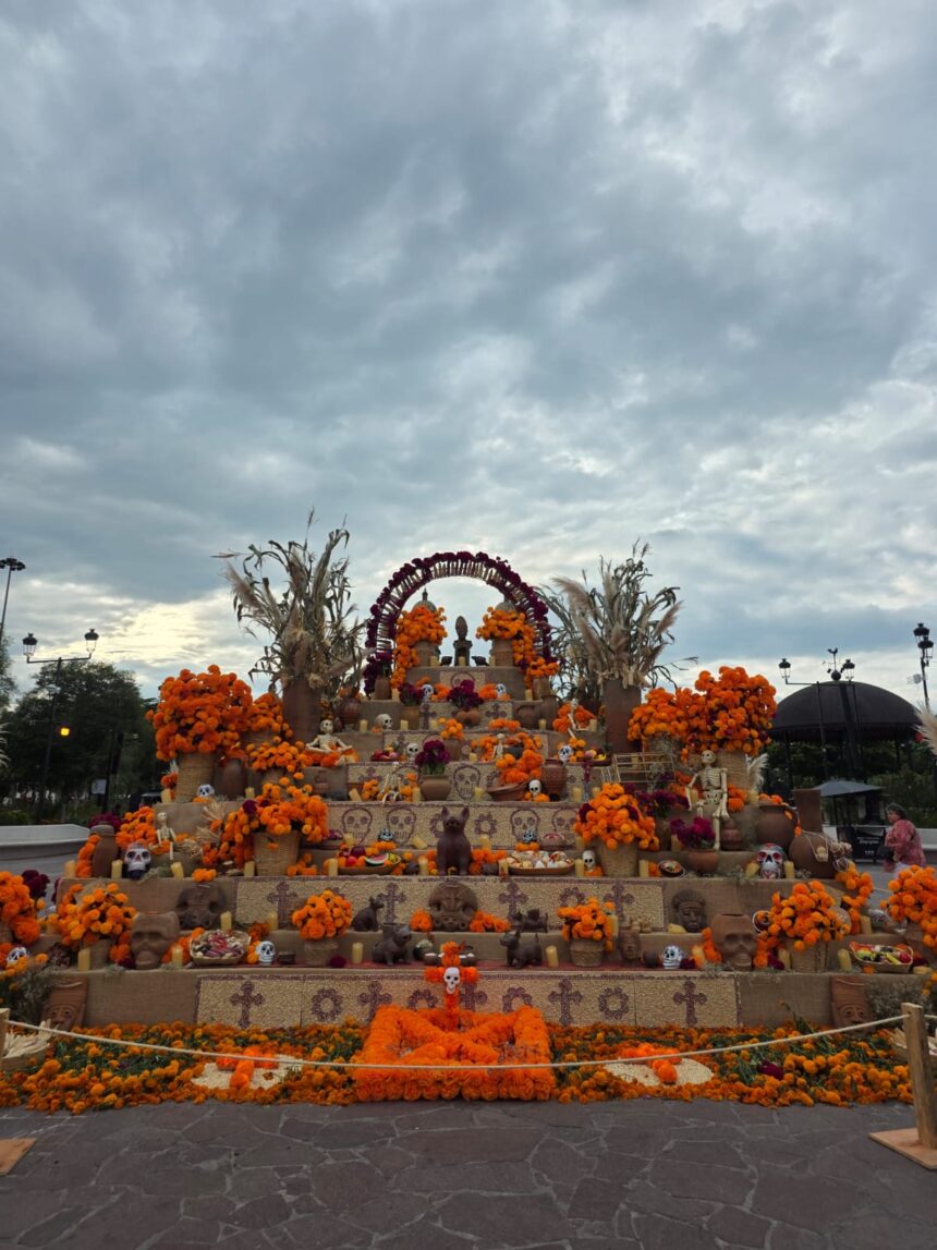 Altar monumental de Día de Muertos decorado con flores de cempasúchil, figuras tradicionales y ofrendas en Zapopan.