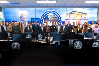 Delegación de visitantes y personal policial posan en el centro de monitoreo del Departamento de Policía de Winston-Salem, frente a pantallas y estaciones de trabajo