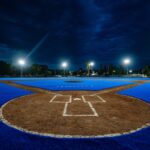Campo de béisbol de la Unidad Deportiva Josefa Ortiz de Domínguez en Querétaro, con superficie azul e iluminación nocturna