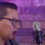 Invitado del pódcast ELPEC durante una entrevista frente a un micrófono en estudio