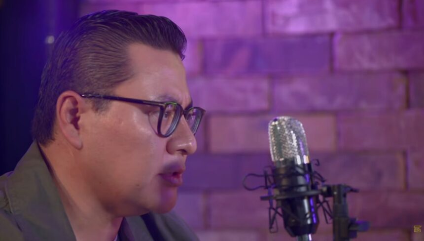 Invitado del pódcast ELPEC durante una entrevista frente a un micrófono en estudio